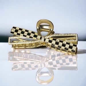 Coco-inspired hair claw. Gold alloy w/ polished black enamel, pavé set stones